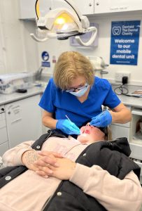 Dentist treating a patient on the mobile dentist unit