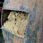 Tank with hole cut out. Hardened sand visible.