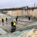 concrete is being laid on the pool floor to reinforce it