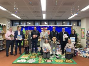 Portsmouth City Council staff and councillors with some of the suppliers who donated presents standing together inside Central Library