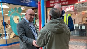 Council leader Steve Pitt speaking to a resident at a pension credit event at the Bridge Centre