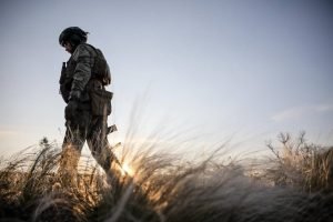 A Ukrainian soldier walking through reeds
