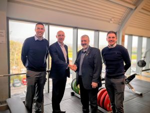 an image of BH Live reps and a local councillor shaking hands in a gym
